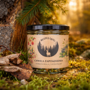 Szklany słoik herbaty białej Chwila Zapomnienia marki Bliżej Lasu stojący na zielonym mchu w lesie, oświetlony ciepłym złotym światłem zachodu słońca.
