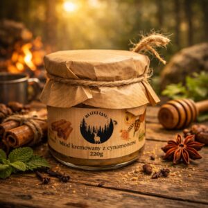 Słoik miodu kremowanego z cynamonem „Bliżej Lasu” na drewnianym stole, w otoczeniu cynamonu i przypraw