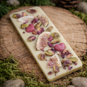 biała czekolada z maliną i dodatkami na drewnianym tle