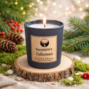 Świeca sojowa „Sosnowy Talizman” w granatowym szkle na drewnianej podstawie, w jasnej leśnej aranżacji z gałązkami sosny i czerwonymi akcentami.