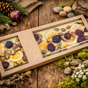 Biała czekolada z mandarynką, jeżyną i pistacjami zapakowana w eleganckie pudełko z okienkiem