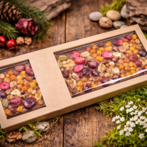 Czekolada mleczna z żurawiną, rokitnikiem i orzechami w ekologicznym opakowaniu na drewnianym tle