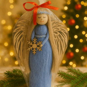anioł stojący w niebieskiej sukni z drewnianymi skrzydłami i śnieżynką w dłoniach, dekoracja świąteczna Bliżej Lasu