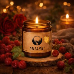 Świeca sojowa MIŁOŚĆ o zapachu maliny w bursztynowym szkle na drewnianym tle w ciepłym świetle